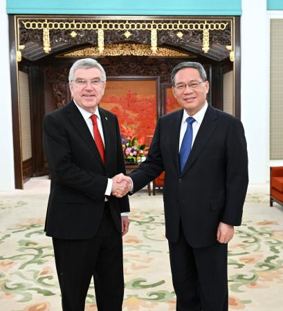 ＩＯＣのバッハ会長（左）と握手する中国の李強首相＝６日、北京の中南海（新華社＝共同）