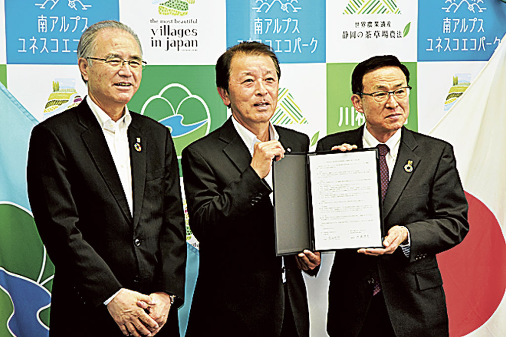 協定書に署名した伊藤理事長（右）と薗田町長ら＝川根本町役場