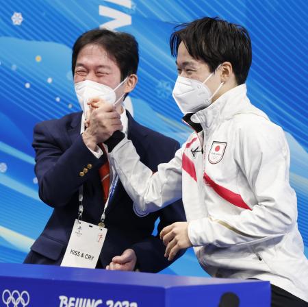 北京五輪で得点を確認し、父の正和コーチ（左）と笑顔で喜ぶ鍵山優真＝２０２２年２月、北京