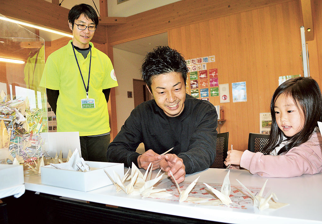 和紙で折り鶴を制作する親子＝静岡市葵区のあさはた緑地