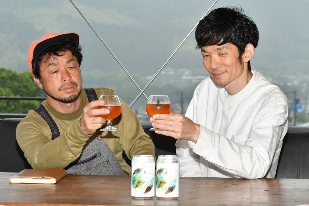 共同開発した発泡酒を楽しむ赤池さん（右）と深沢さん＝富士宮市内