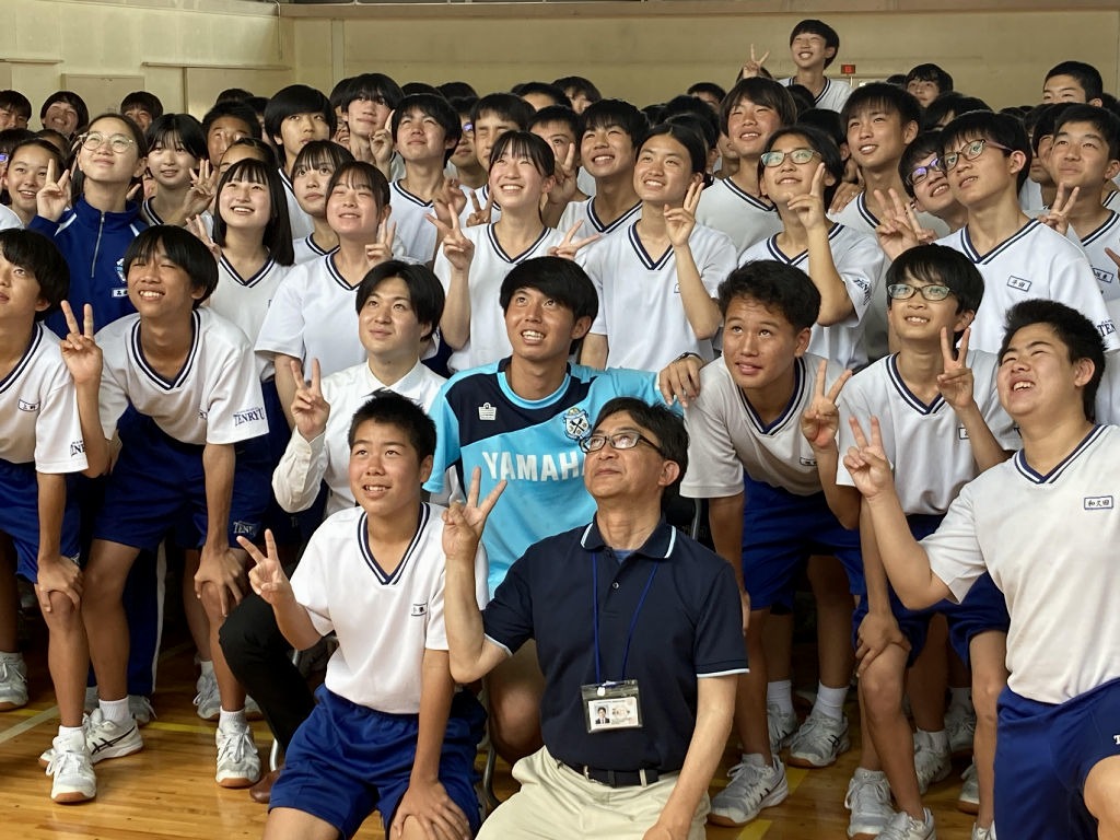 生徒たちと記念撮影する鈴木選手（中央右）と富山さん（同左）＝浜松市東区の市立天竜中