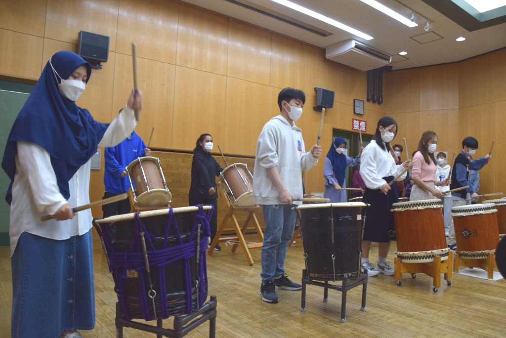 太鼓の演奏体験を楽しむ留学生ら＝浜松市南区の可美協働センター