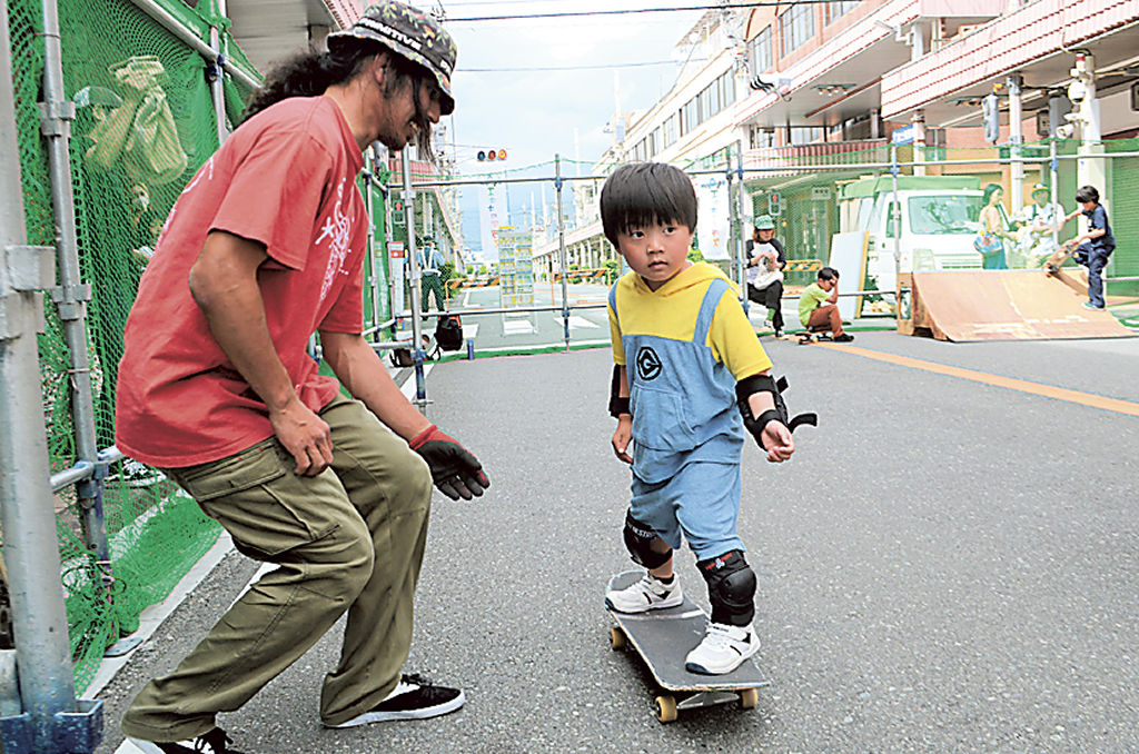スケートボードを教わる子ども＝富士市の富士本町通り