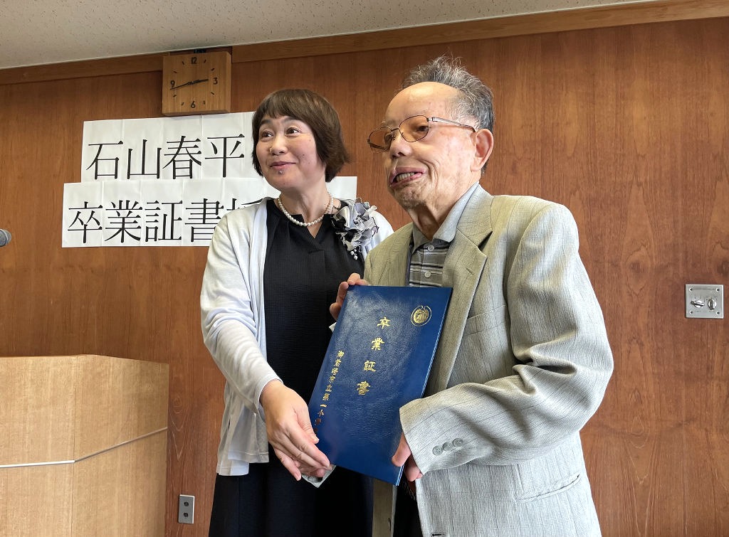 ７５年遅れの卒業証書を受け取る石山春平さん（右）＝１日午後、静岡市葵区