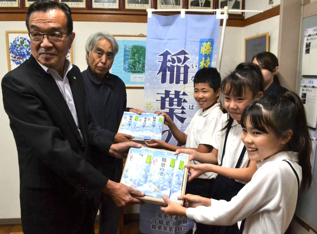 地元産の新茶を児童に贈呈する下田会長（左）ら＝藤枝市立稲葉小