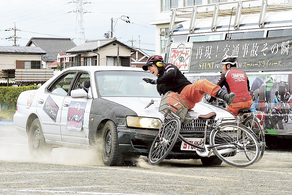 自転車事故を実演するスタントマン＝静岡市駿河区の高松中
