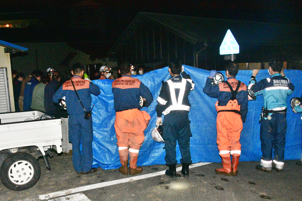 土砂崩れ現場で見つかった男性の遺体を運ぶ消防隊員ら＝４日午前１時２５分ごろ、浜松市北区引佐町渋川