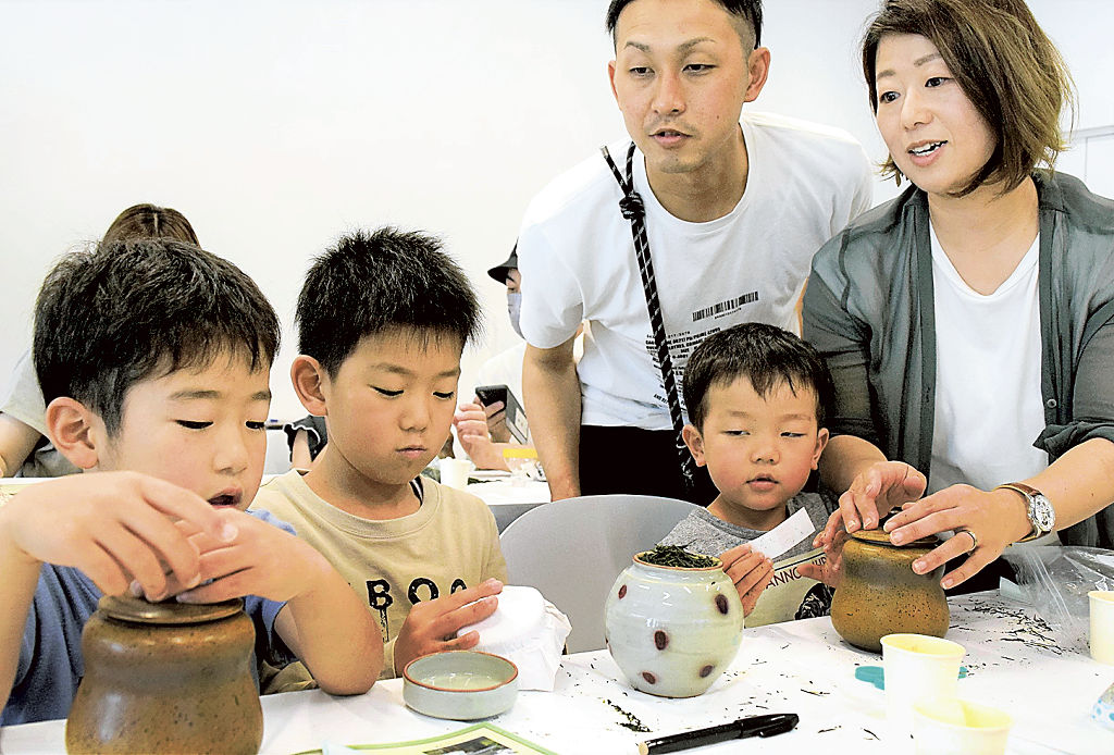 熟成させるため、茶をつぼに詰める参加者＝静岡市葵区の市歴史博物館