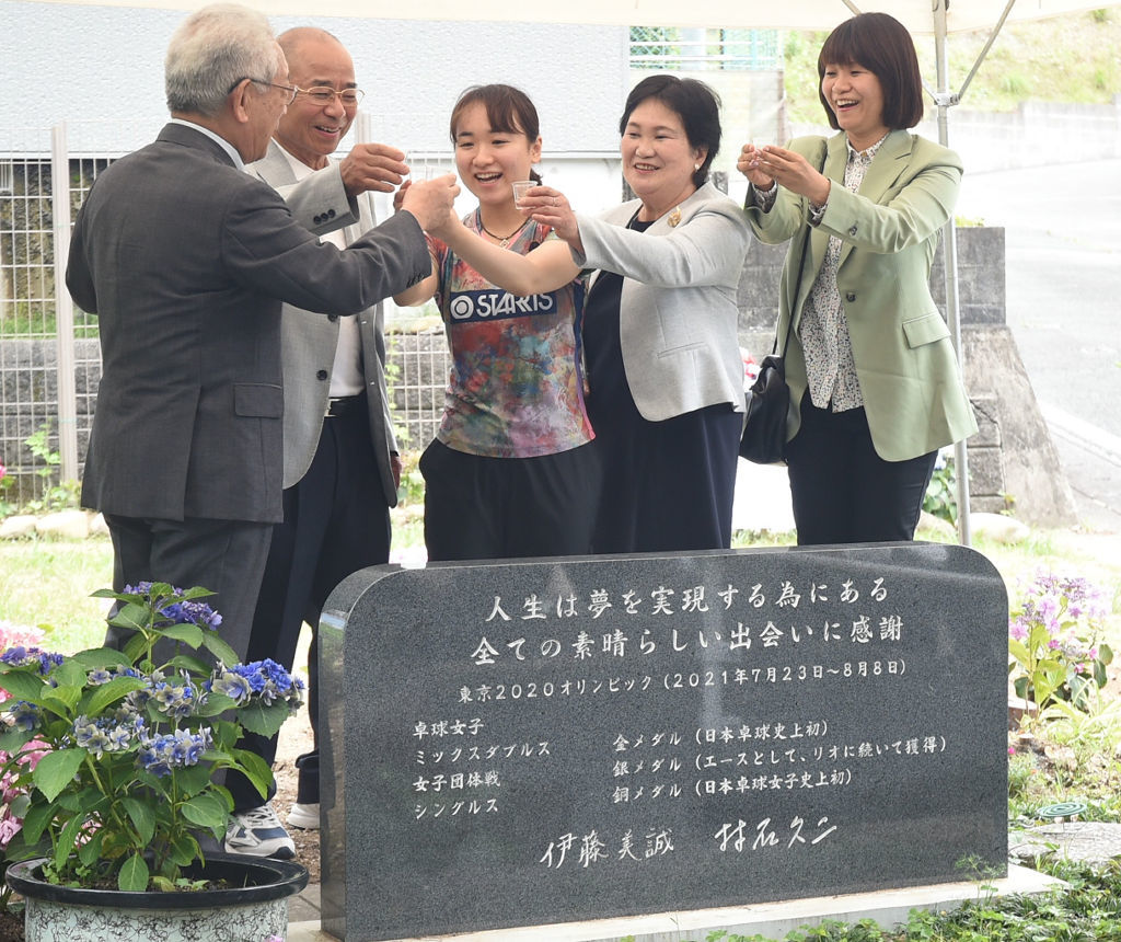 東京五輪金メダルを記念し祖父健一さん（左から２人目）が建立した石碑のお披露目を祝う伊藤美誠選手（中央）ら＝磐田市