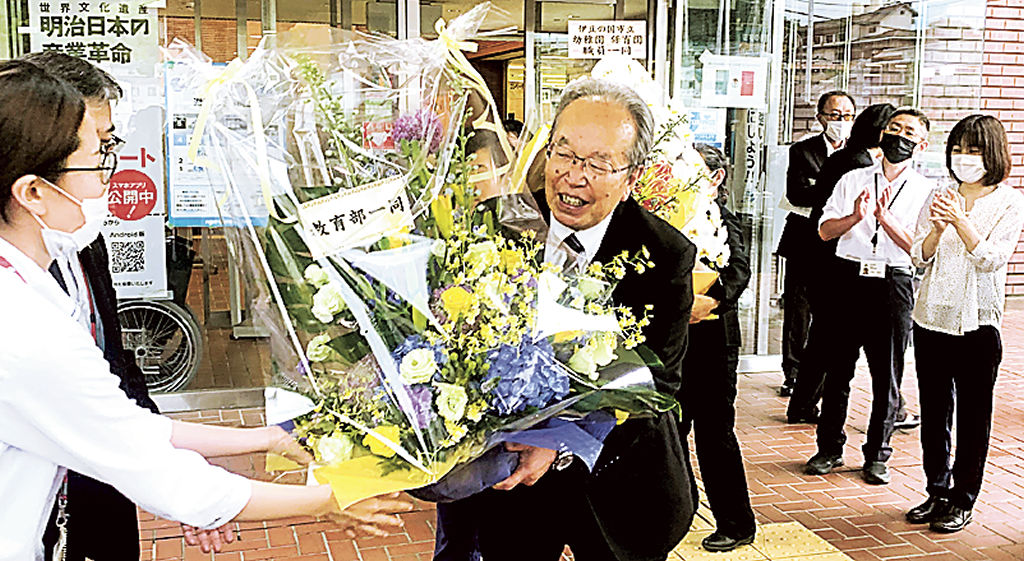 花束を受け、笑顔で庁舎を後にする増田氏＝伊豆の国市役所