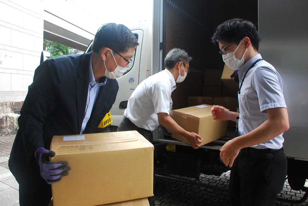保管期間が終了した投票用紙を積み込む職員ら＝１４日午前、三島市