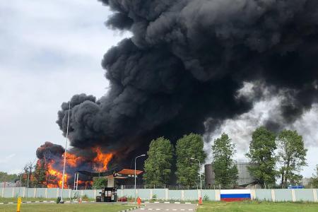 ２４日、ロシア南部ボロネジで炎を上げる燃料タンク（タス＝共同）