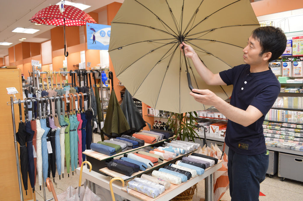 小売店の傘コーナー。大きめの晴雨兼用傘が性別を問わず人気という＝６月中旬、静岡市葵区の三保原屋