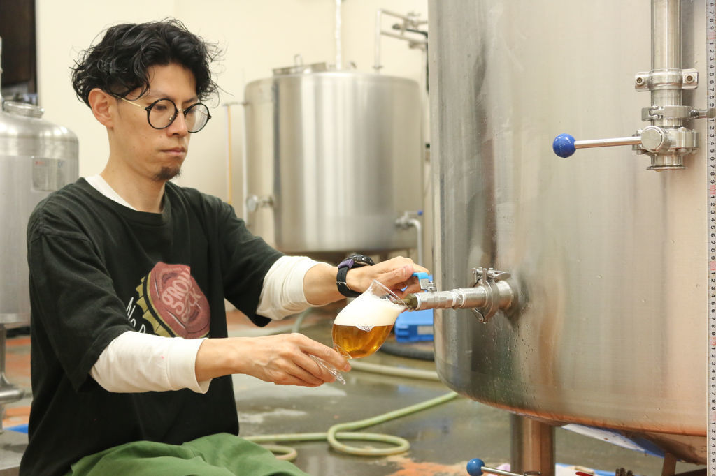 タンクから試飲用のビールを取り出す福島代表＝静岡市葵区のアオイブリューイング