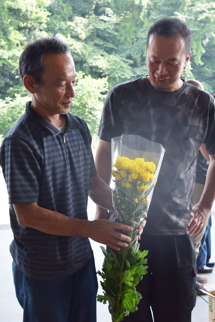 スプレー菊を手に取り、状態を確認する生産者ら＝浜松市中区のＪＡとぴあ浜松花き営農センター
