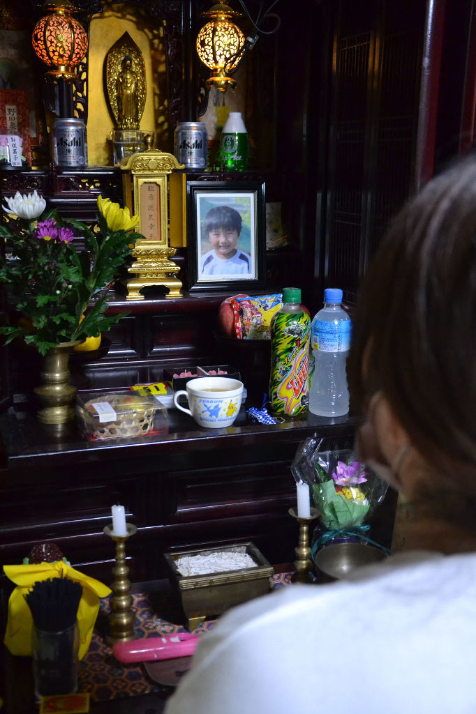 仏壇に供えた倉掛冬生ちゃんの遺影を見つめる母。１年余りで悲劇が繰り返されたことに心を痛める＝２２日、福岡県中間市