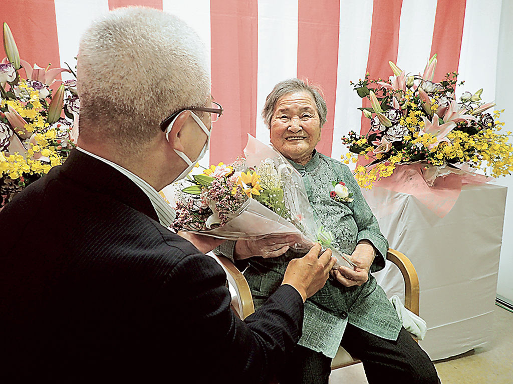 深沢町長から花束を受け取る舩津さん（右）＝西伊豆町
