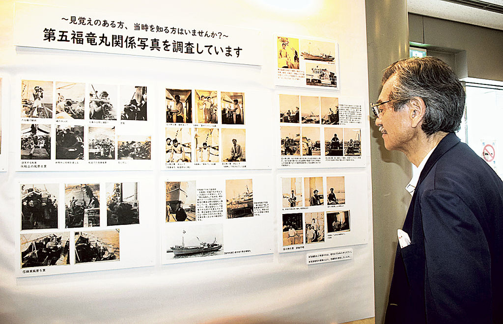 第五福竜丸の貴重な写真を見る安田和也さん（右）＝３０日午後、焼津市三ケ名の市歴史民俗資料館