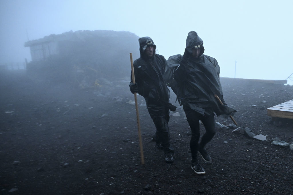 激しい風雨の中を歩く登山客。御来光は望めなかった＝１日午前４時４０分ごろ、富士山頂（写真部・小糸恵介）