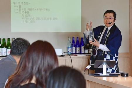 日本酒の説明をする在韓日本大使館の中條一夫公報文化院長＝２７日、ソウル（共同）