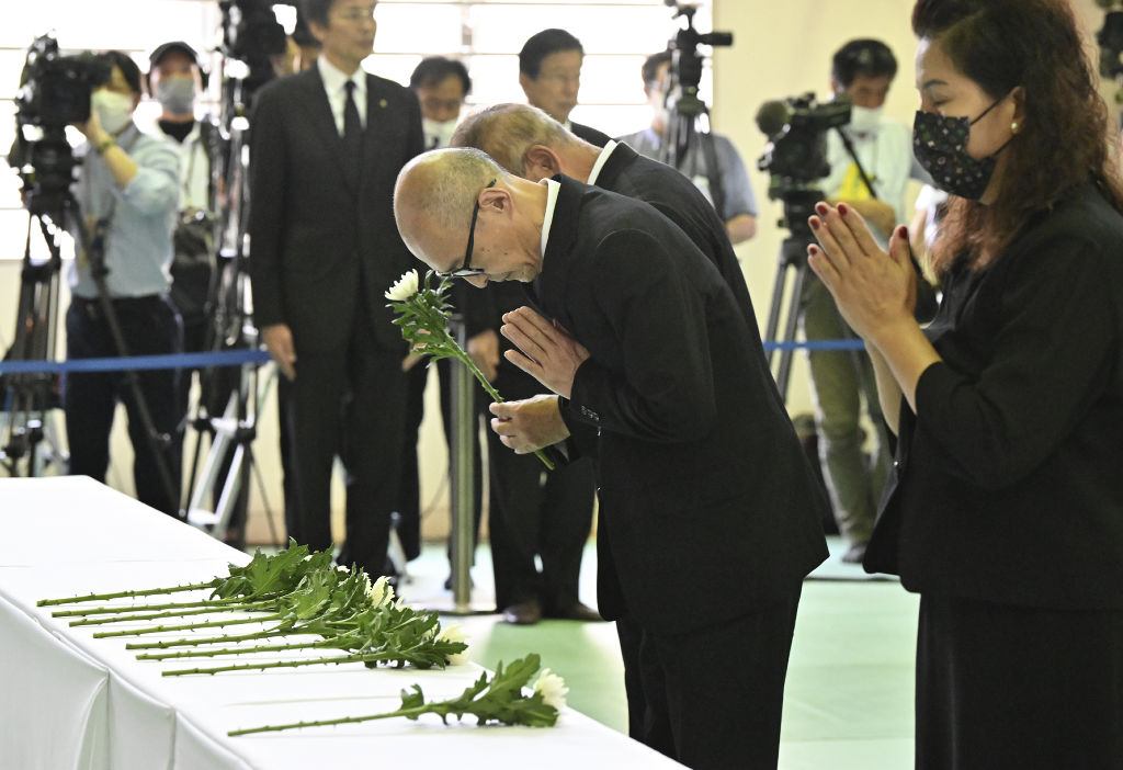 追悼式で献花する太田朋晃さん（中央）＝３日午前、熱海市立伊豆山小