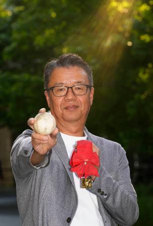 甲子園でのホームランボールと優勝メダルを手にする山口博史さん＝５月、東京都港区