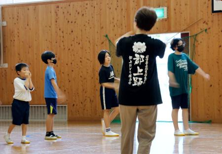 岐阜県郡上市の体育館で、郡上踊の練習をする保存会メンバーと小学生ら＝１０日