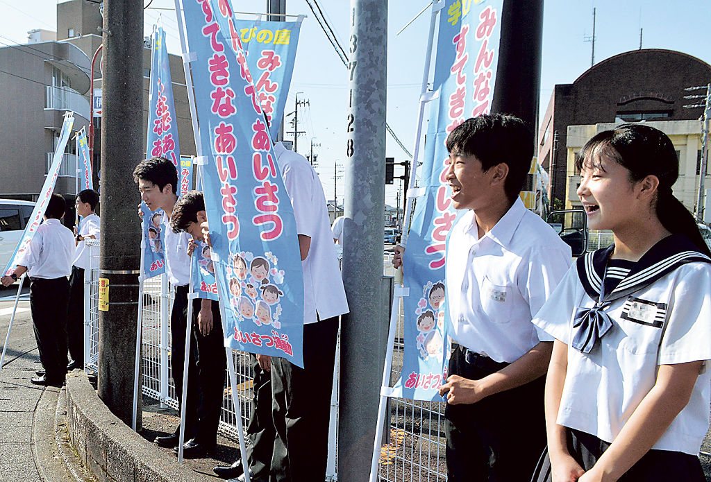 のぼり旗を手に朝のあいさつをする生徒たち＝菊川市堀之内