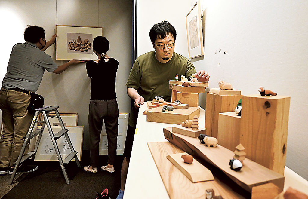 作品の展示角度を調整する川崎さん（右）＝静岡市駿河区の駿府博物館