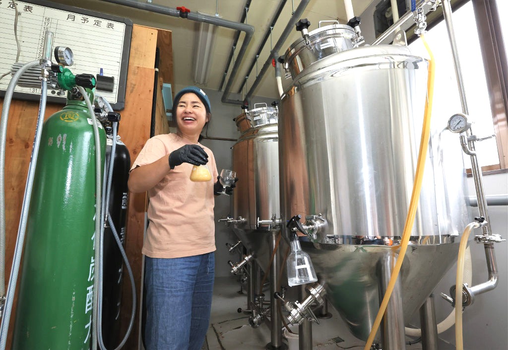 ビールの発酵具合を確かめる冨成和枝さん＝長野県伊那市の「イナデイズ　ブルーイング」