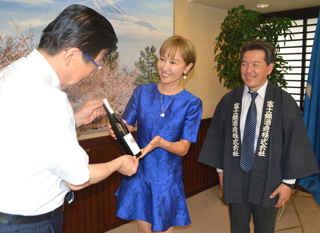 川勝平太知事（左）に日本酒を贈呈する工藤夕貴さん＝県庁