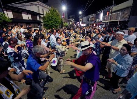 「郡上踊」が始まり、浴衣姿で踊る大勢の人たち＝１５日夜、岐阜県郡上市