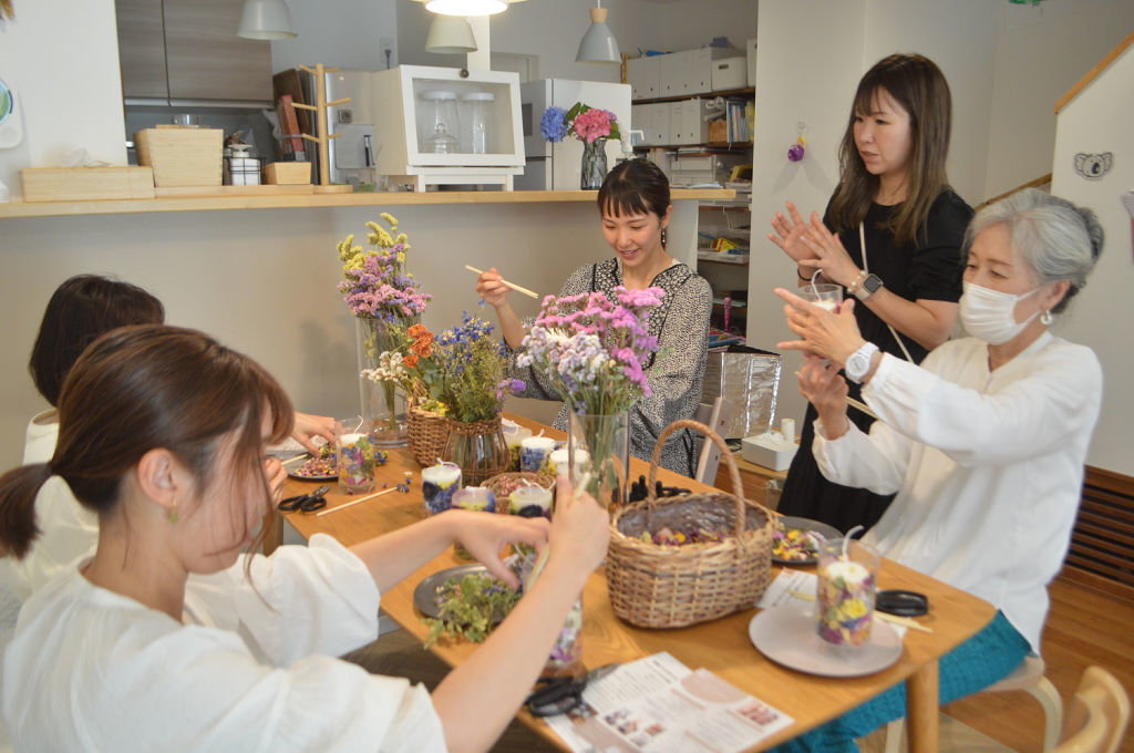 廃棄花を活用したキャンドル作りのワークショップを展開する元川恵さん（右から２人目）＝静岡市内