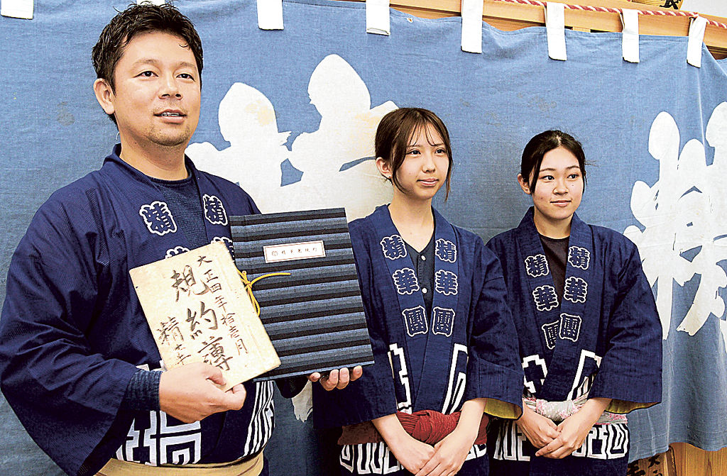 新旧の規約を手に初の女性団員を迎える石川さん（左）＝浜松市東区笠井町