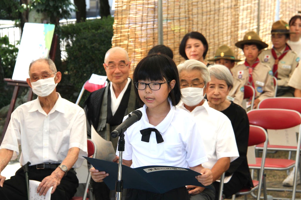 平和への誓いを読み上げる永房さん＝島田市の扇町公園