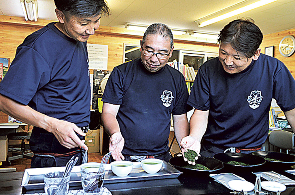 お茶の外観や水色を確認する斎藤徹社長（中央）ら＝２７日午前、掛川市伊達方の山啓製茶