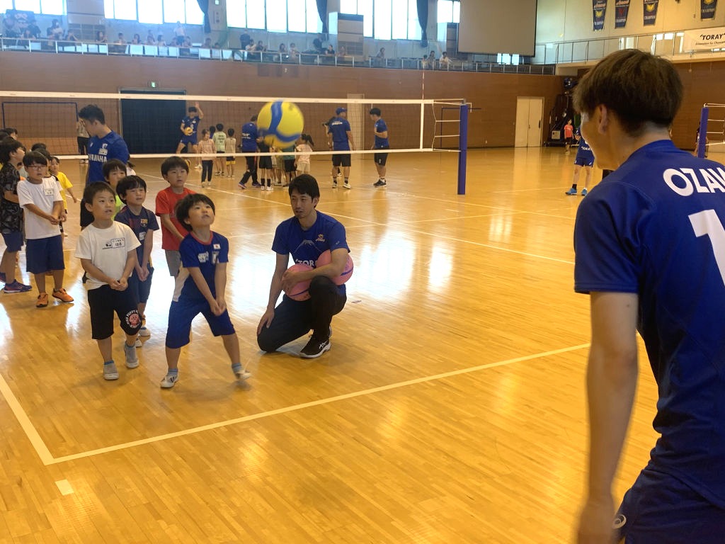 バレーボールのレシーブに挑戦する児童ら=三島市の東レ体育館