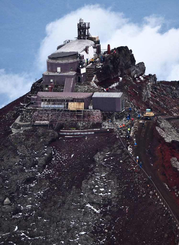 うっすらと雪に覆われた富士山の剣が峰。登頂を果たした登山者らの姿が見えた＝１日午前（本社ヘリ「ジェリコ１号」から、写真部・久保田竜平）