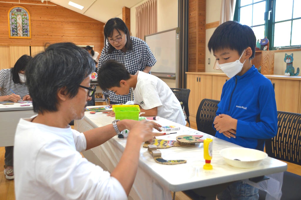 よこたさん（左）の指導を受けながら、ネコ型の作品作りに取り組む参加者＝磐田市上新屋の新造形創造館