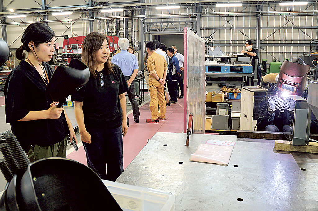 説明会後に自社工場を案内する山崎かおり代表（左から２人目）＝７月上旬、静岡市清水区の山崎製作所