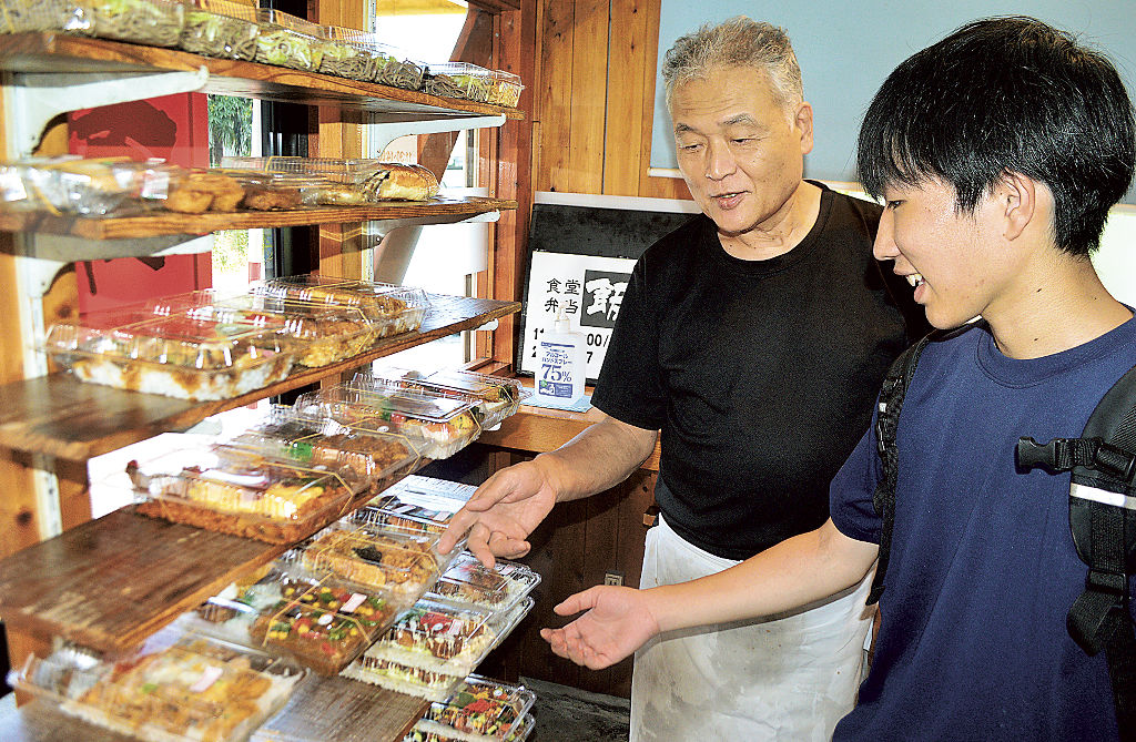 昼時に弁当を選ぶ学生と山崎さん（左）＝静岡市駿河区大谷