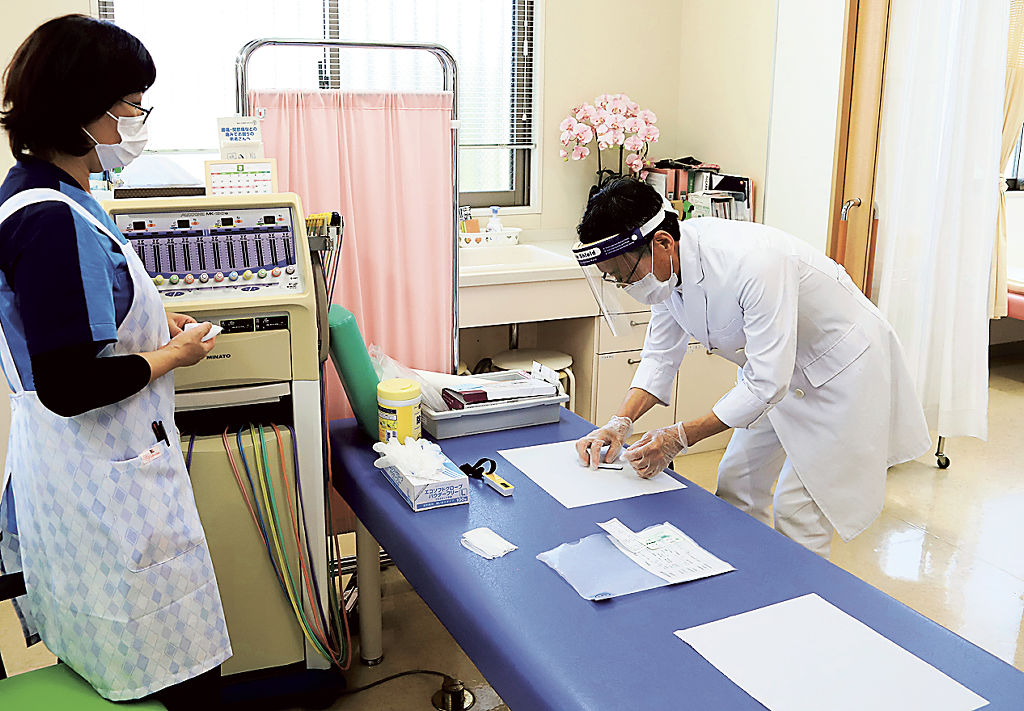 抗原検査を行う古川敬芳院長（右）。この日は午前の診療で４人の陽性が確認された＝５日、静岡市葵区のしずおか葵の森クリニック