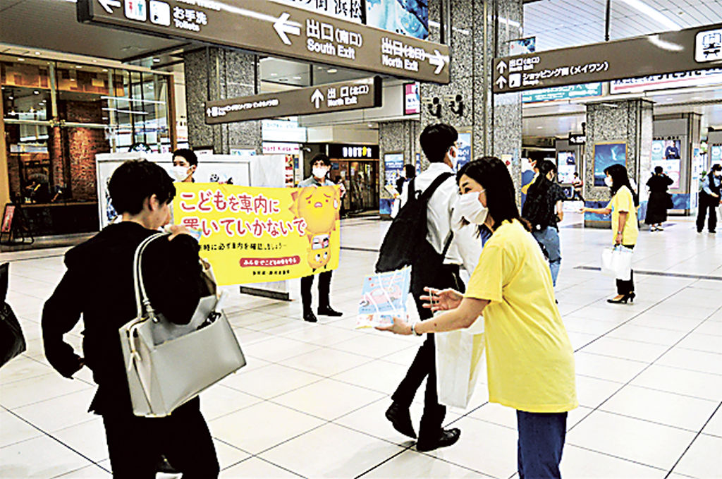 子どもの車内置き去り防止を呼びかけたチラシを配る県職員ら＝ＪＲ浜松駅