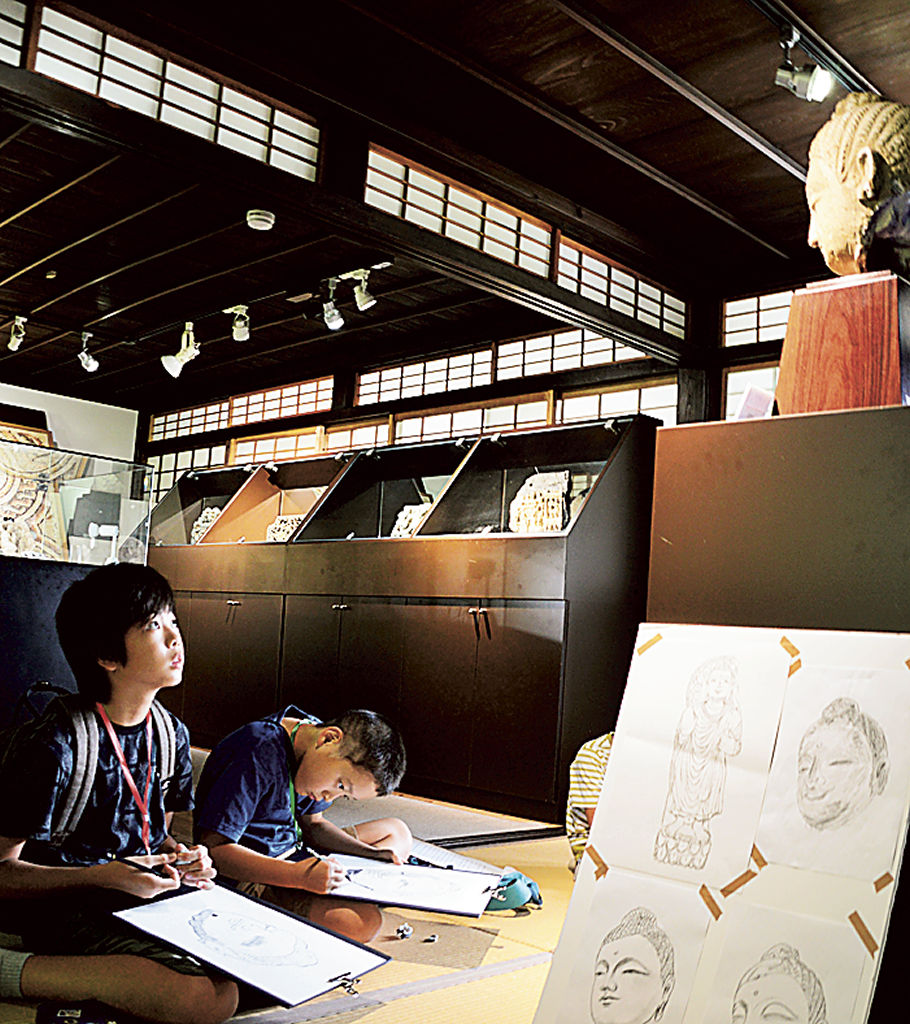お気に入りの仏像をスケッチする児童たち＝磐田市上野部のシルクロード・ミュージアム