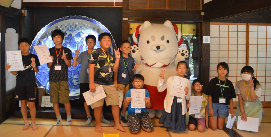 しっぺいから修了証を受け取った児童たち＝磐田市上野部のシルクロードミュージアム