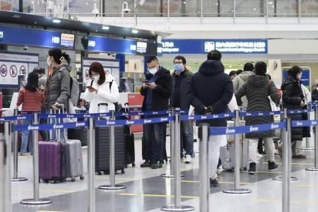 ２月、海外への団体旅行が解禁される便の搭乗手続きのため列に並ぶ人たち。当時、日本は含まれていなかった＝北京首都国際空港（共同）