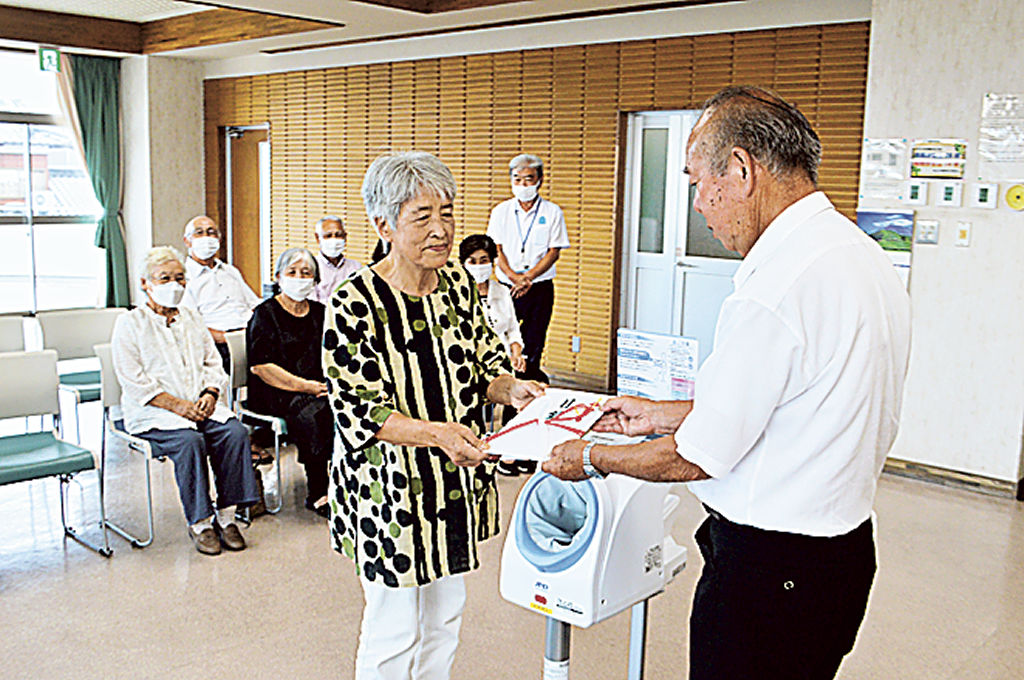 目録を渡す支部員（左）＝富士市の須津まちづくりセンター