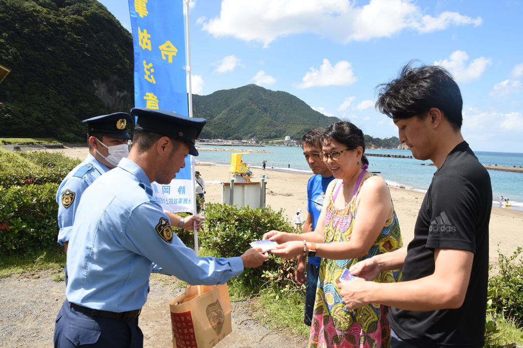 水難事故防止を呼び掛ける署員ら＝西伊豆町宇久須のクリスタルビーチ