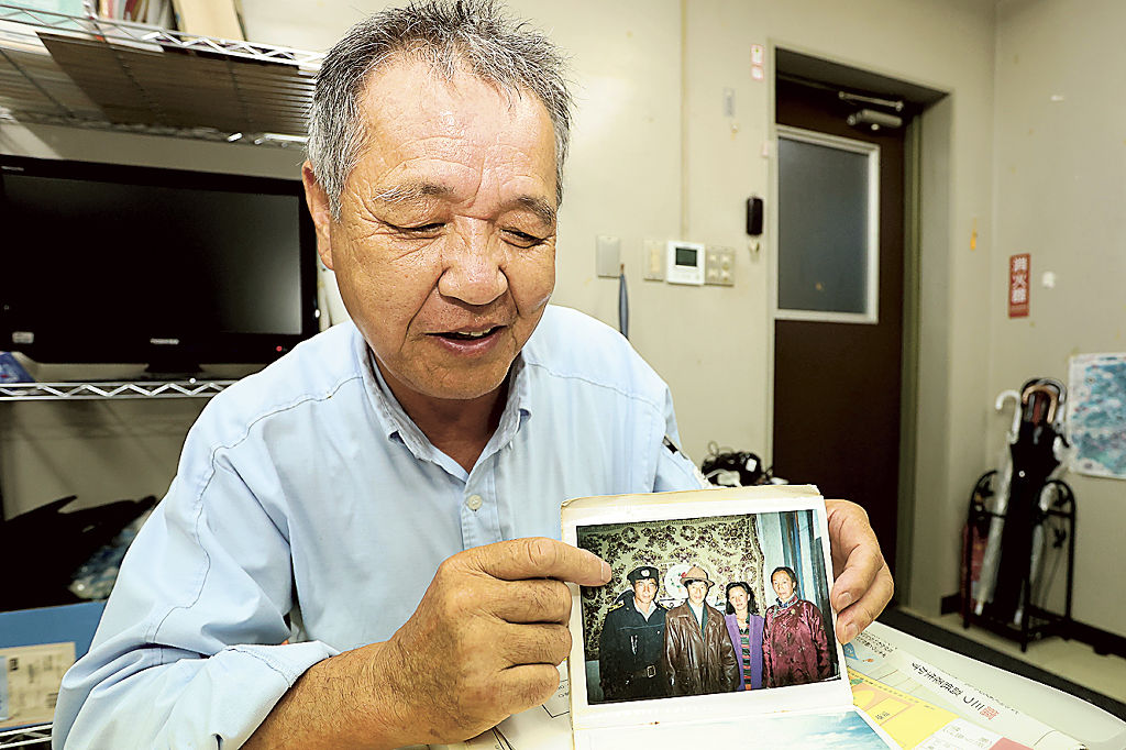 ２６年前の写真を手に再会への思いを語る吉川さん＝袋井市内